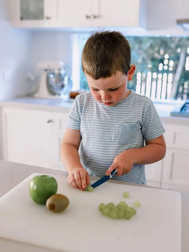 little-boy-cutting-grapes-aplles-and-kiwi-fruit-with-blue-kiddikutter-e1622797025571